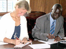 Former Pangaea Global AIDS Foundation President Pat Christen (left) and Makerere University Vice Chancellor Livingstone Luboobi sign documents to transfer ownership of IDI
