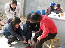 Dr. Warne and training group colleagues examine a patient in a rural clinic near Lixin